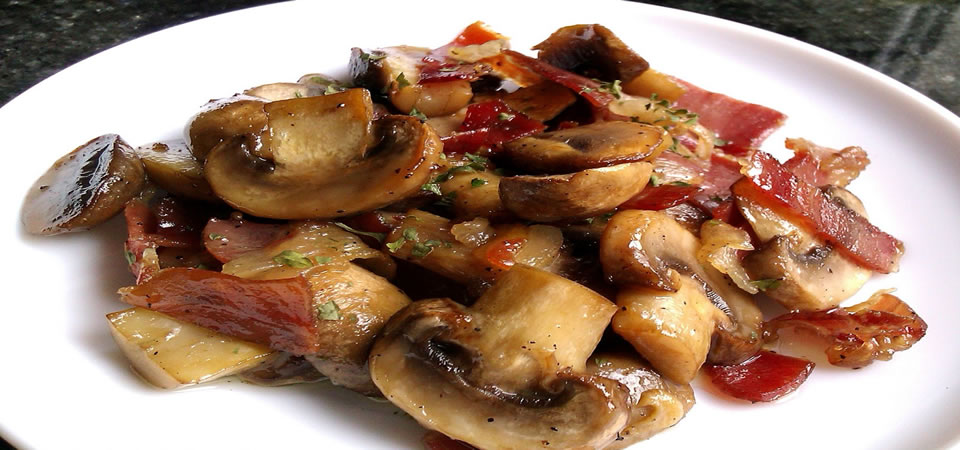 Plat de champignons avec une sauce &agrave; l'ail pil&eacute; et &agrave; l'huile avec jambon ib&eacute;rique